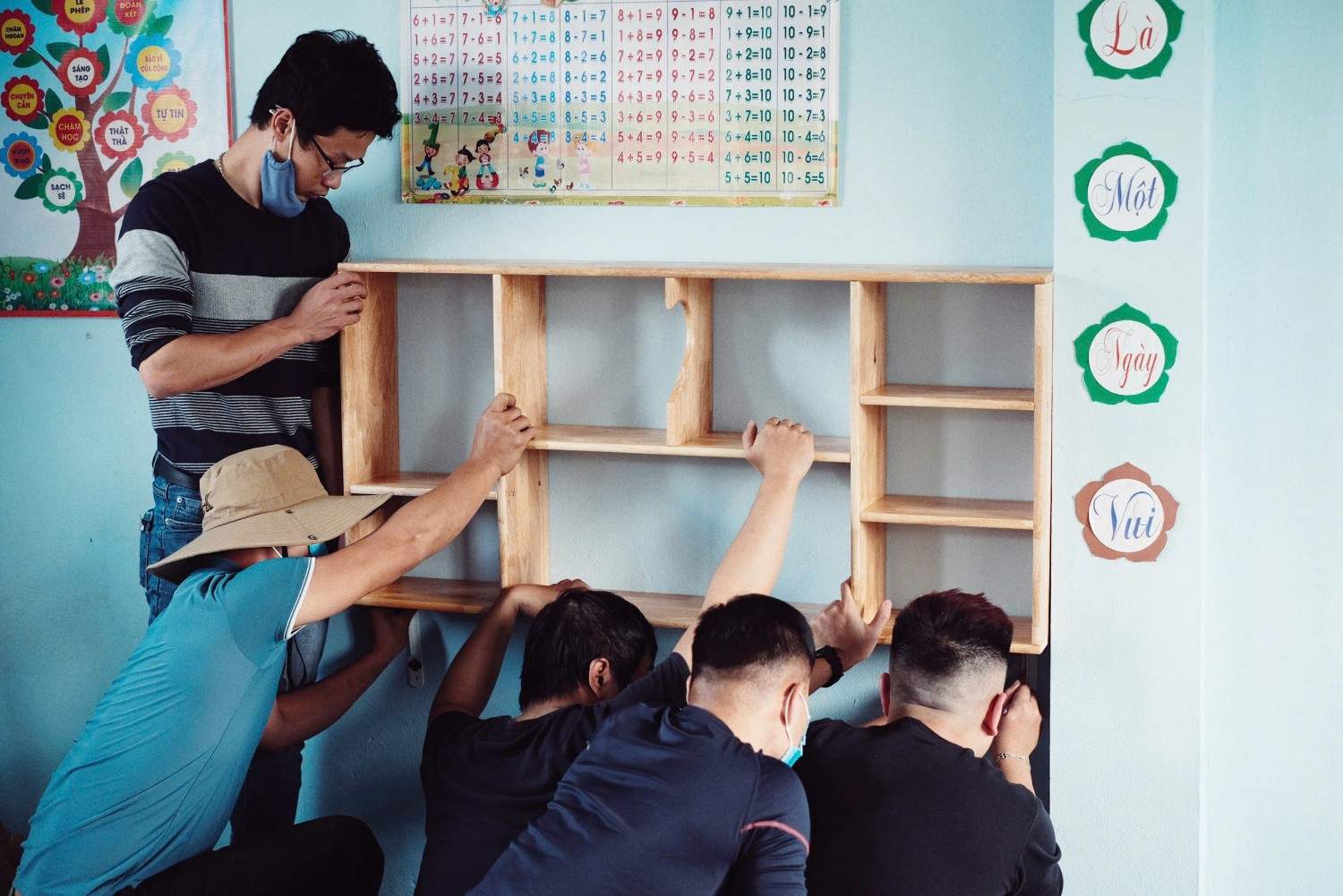 Những thành viên của Quỹ Đèn Đom Đóm tự tay chuẩn bị sách vở, trang trí tường... cho ngày khánh thành điểm trường Nậm Tần Mông. Ảnh: NVCC 