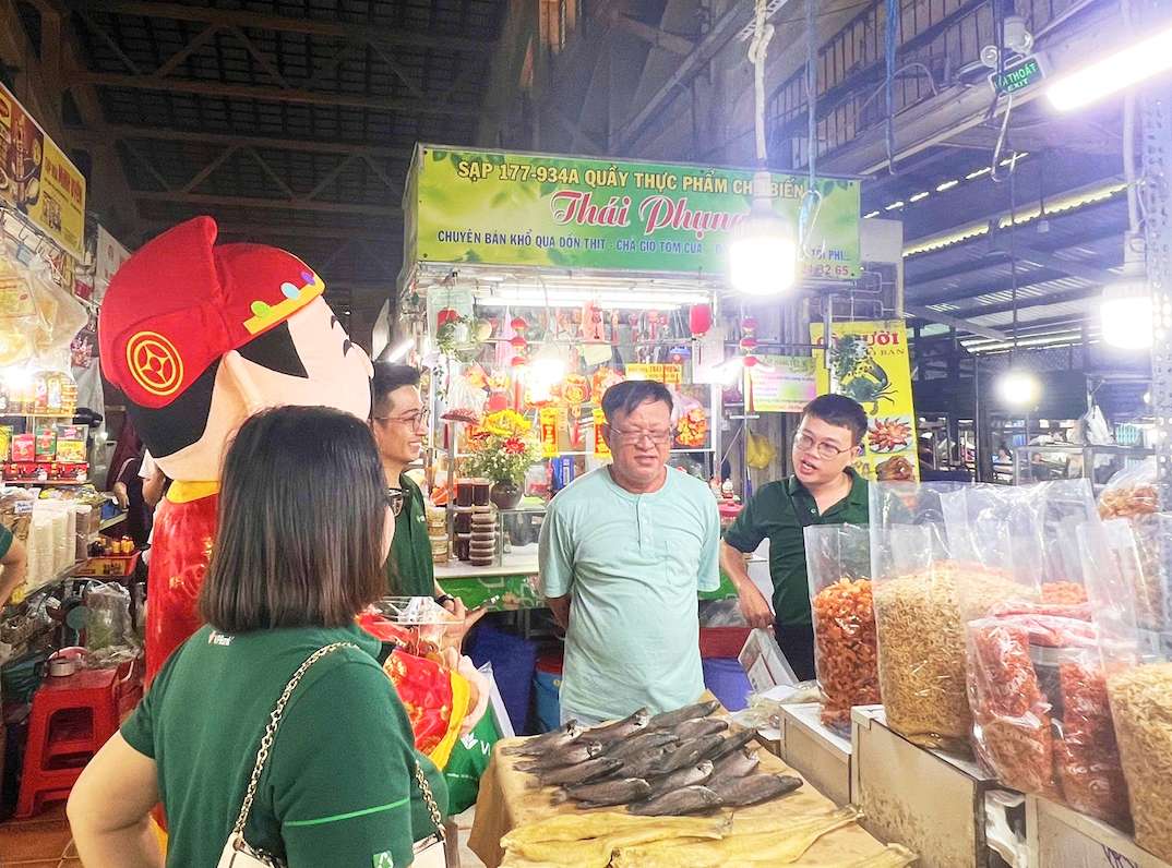 Hộ kinh doanh tại chợ Tân Định (TP.HCM) tiếp cận các thông tin về quy định mới và ưu đãi từ VPBank CommCredit. Ảnh: VPBank