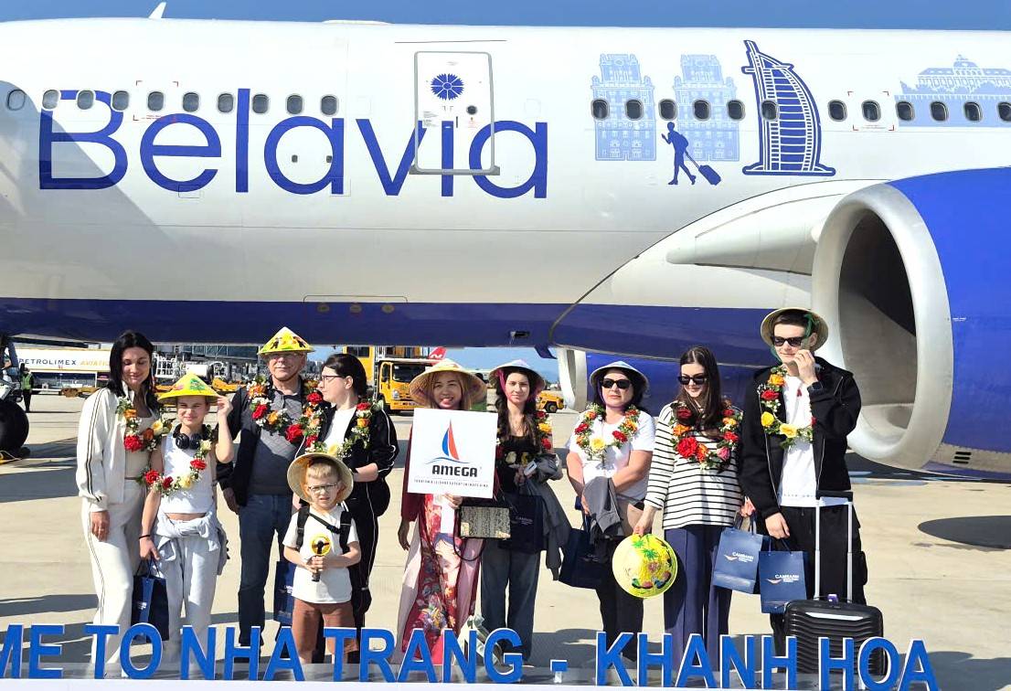 Những hành khách đầu tiên trên chuyến bay rất vui vẻ khi được chào đón với hoa, quà lưu niệm khi đặt chân xuống Cảng hàng không quốc tế Cam ranh. Ảnh: Nguyễn Phát