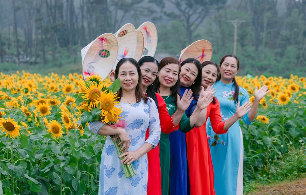 Hình ảnh những tà áo dài thướt tha nổi bật giữa sắc vàng hướng dương tạo nên điểm nhấn ấn tượng cho không gian làng quê.