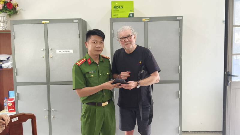 Công an xã Mai Châu trao trả lại chiếc điện thoại cho ông Regnauld Charles. Ảnh: Bộ Công an  