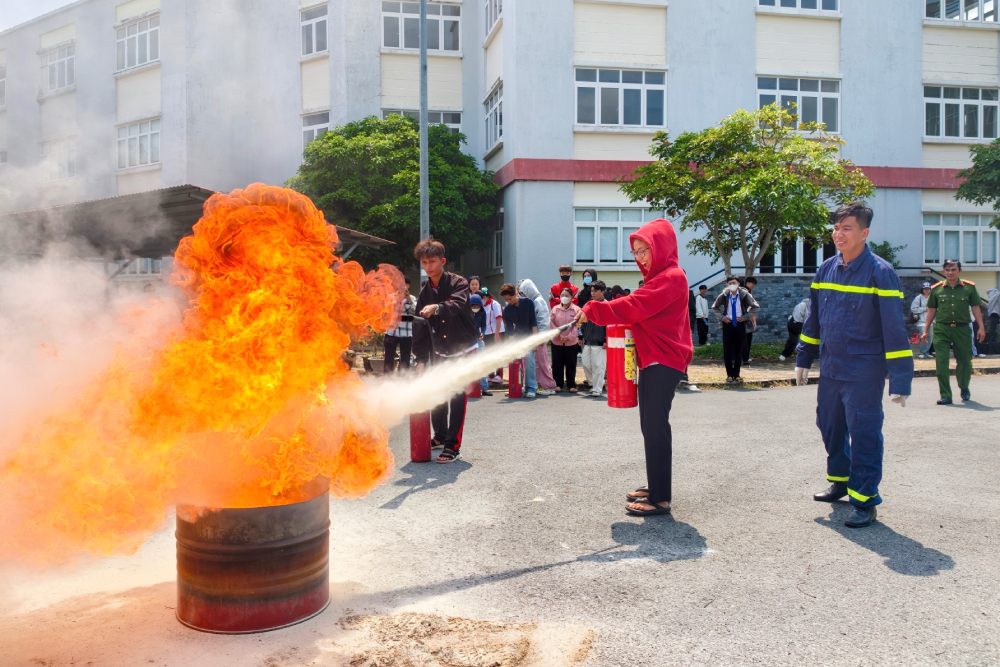 Sinh viên thực hành sử dụng bình chữa cháy xách tay để dập tắt đám cháy giả định. Ảnh: Công an Cần Thơ