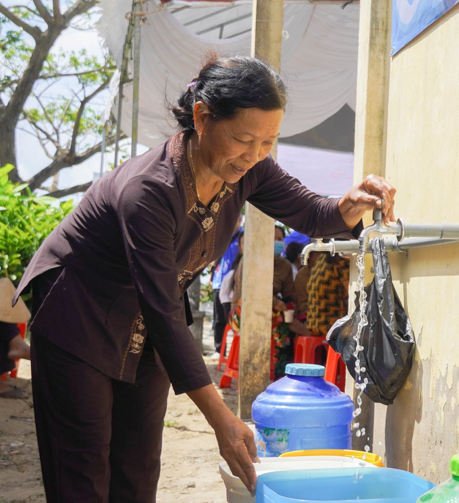 Người dân phường Khánh Hòa phấn khởi khi được tiếp cận nguồn nước sạch từ hệ thống lọc nước nhiễm mặn. Ảnh: Phương Anh