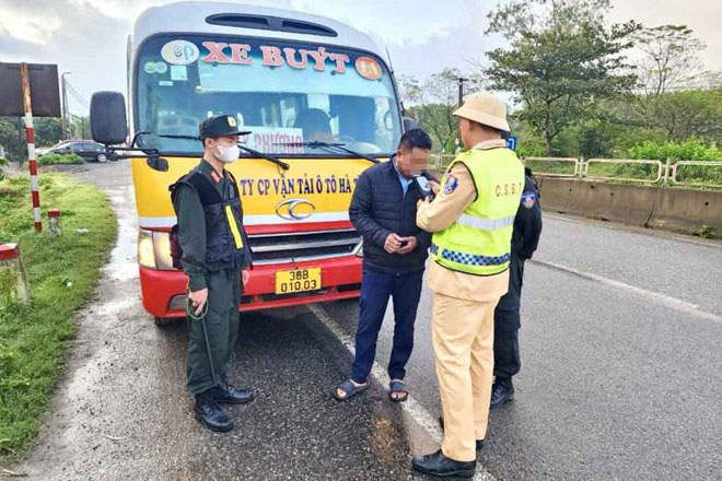 Cảnh sát giao thông Hà Tĩnh kiểm tra nồng độ cồn với tài xe xe buýt. Ảnh: Hoàng Anh