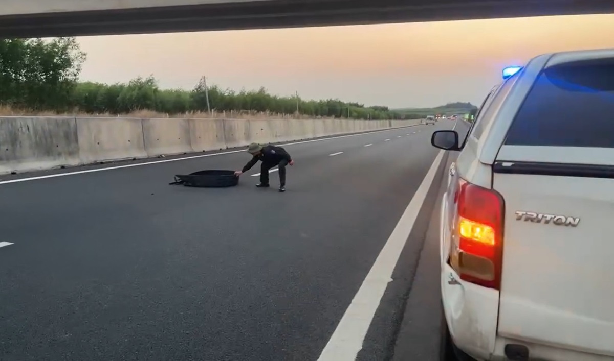 Tổ tuần tra Cảnh sát Giao thông kéo mảnh lốp vỡ ra khỏi mặt đường cao tốc. Ảnh: 