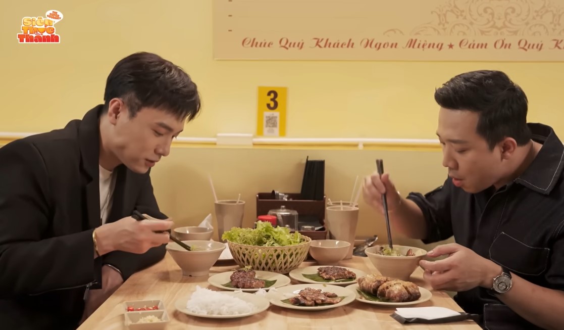 Trấn Thành và ca sĩ Phạm Anh Duy thưởng thức bún chả ở cơ sở TP.HCM. Ảnh: Youtube nhân vật