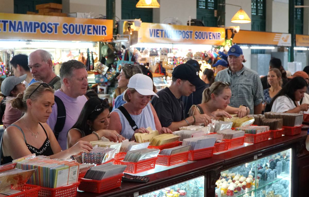 Du khách tham quan, mua đồ lưu niệm tại Bưu điện Thành phố. Ảnh: Thanh Chân