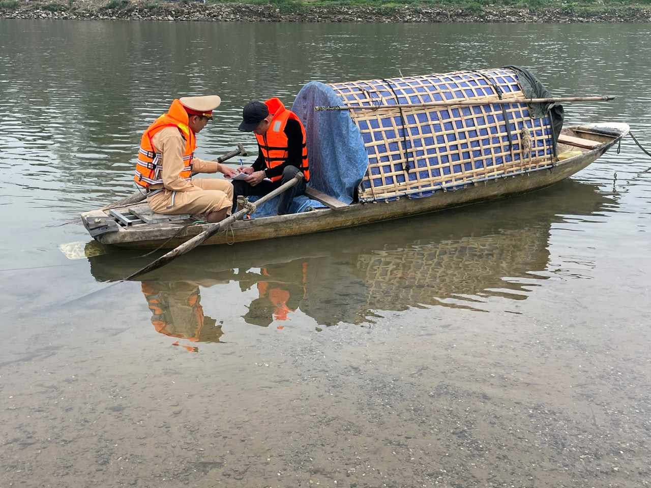 Functional forces request families with vehicles and rafts on the river to sign commitments to wear life jackets and lifebuoys when participating in waterway traffic. Photo: Thanh Phong