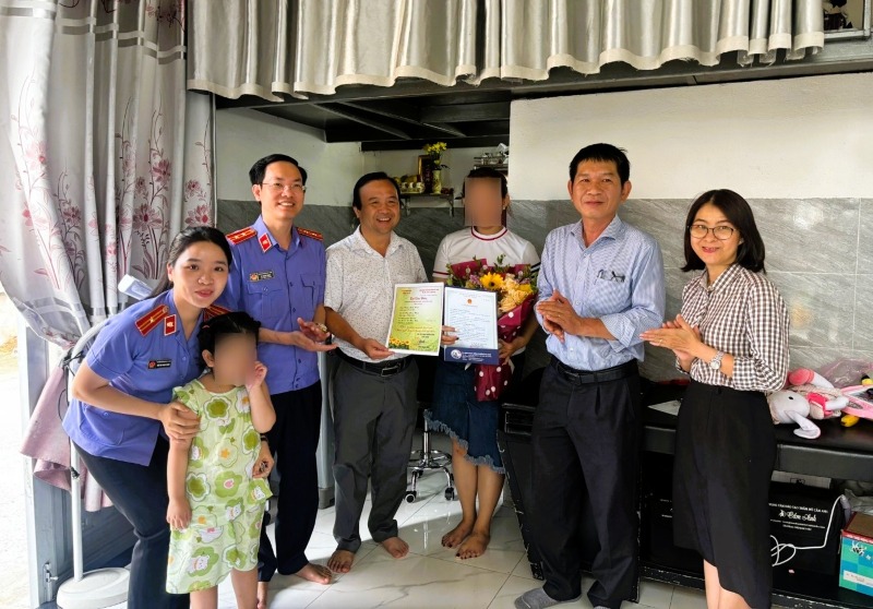 VKSND khu vực 3 phối hợp cùng UBND phường An Khê, Đà Nẵng trao giấy khai sinh cho bé gái. Ảnh: T. Tráng