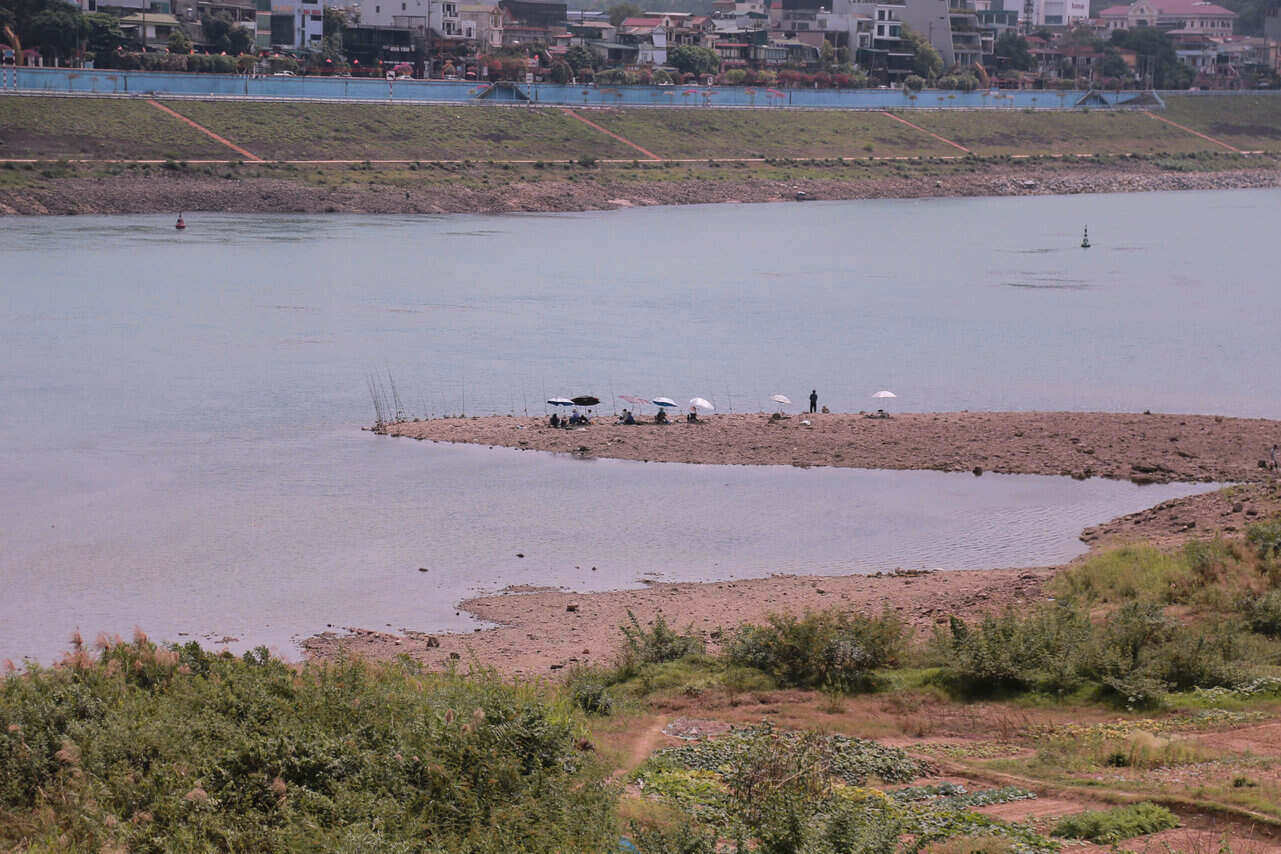 People go down to the middle of the Da River to fish when the water level drops low. Photo: Minh Chuyen