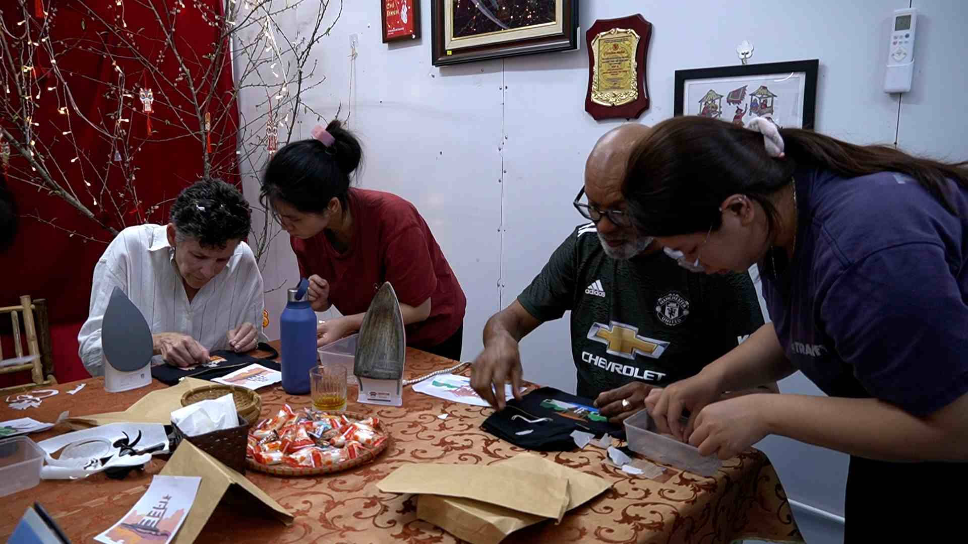 Khách Tây hào hứng làm đồ thủ công từ vải vụn tại Vụn Art dưới sự hỗ trợ nhiệt tình của những nhân viên đặc biệt. Ảnh: Phương Anh