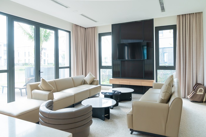 Ảnh 9: Trong mỗi căn biệt thự, không gian sống được thiết kế đầy đủ tiện nghi với phòng khách rộng rãi, khu bếp hiện đại và hệ thống giải trí cao cấp, mang đến cảm giác như một tổ ấm thực thụ. Người bệnh và gia đình không chỉ được chăm sóc y tế an toàn, mà còn tận hưởng không gian sống sang trọng, riêng tư, hòa mình với thiên nhiên trong suốt hành trình hồi phục.