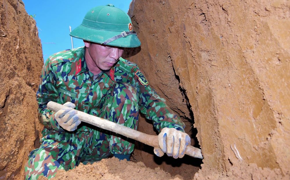 The Team for Repatriating Martyrs' Remains of Economic - National Defense Team 337 performs the task of searching for martyrs' remains in Cha Ly mountain crevice. Photo: Team 337