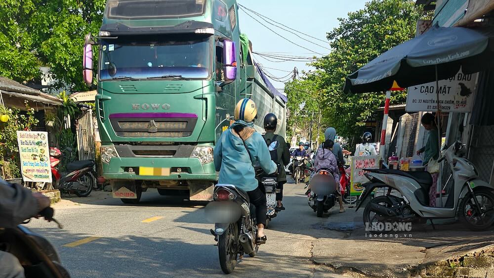 Để vào trạm trộn bê tông của Công ty Cổ phần Bê tông và Xây dựng Thừa Thiên Huế xả hàng, các xe đầu kéo trọng tải lớn phải đi trên tuyến đường chật hẹp, đông dân cư. Ảnh chụp xe đầu kéo mang BKS 75H - 020.XX kéo theo thùng 75RM 000.XX lúc 8h14 ngày 19.3. Ảnh: Phóng viên

