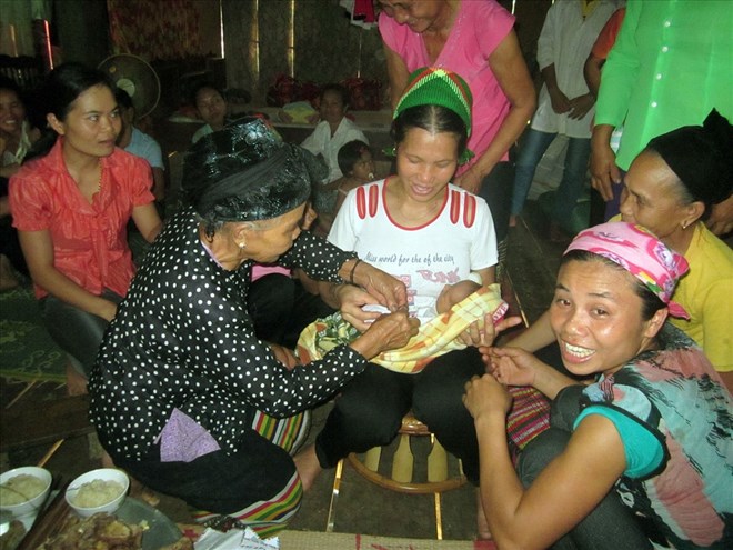 Custom of tying fingerprints for children in the Thai ethnic people's naming ceremony in Con Cuong (Nghe An). Photo: Huu Vi