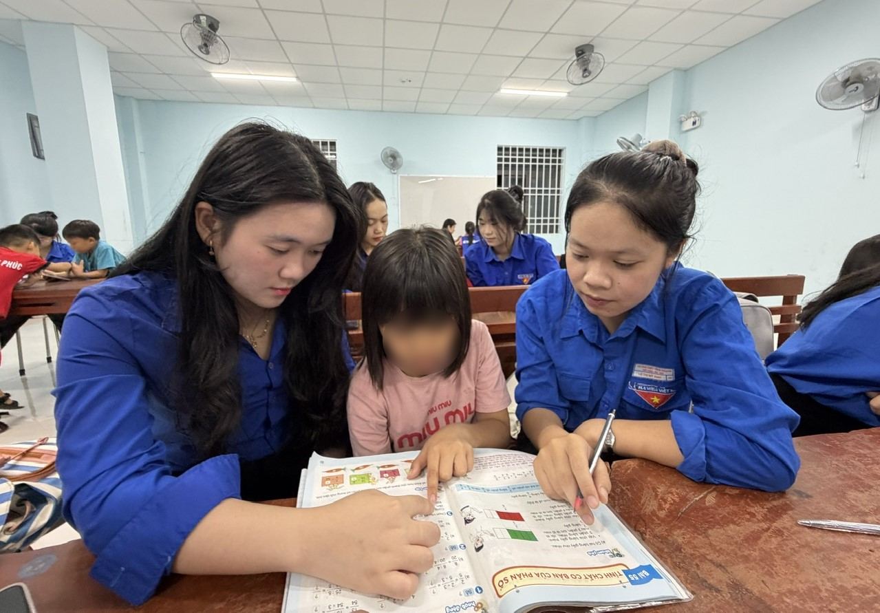 Des étudiants de l'université Phạm Văn Đồng accompagnent les élèves dans leurs études au Centre de travail social de la province de Quảng Ngãi. Photo: Đông Giang
