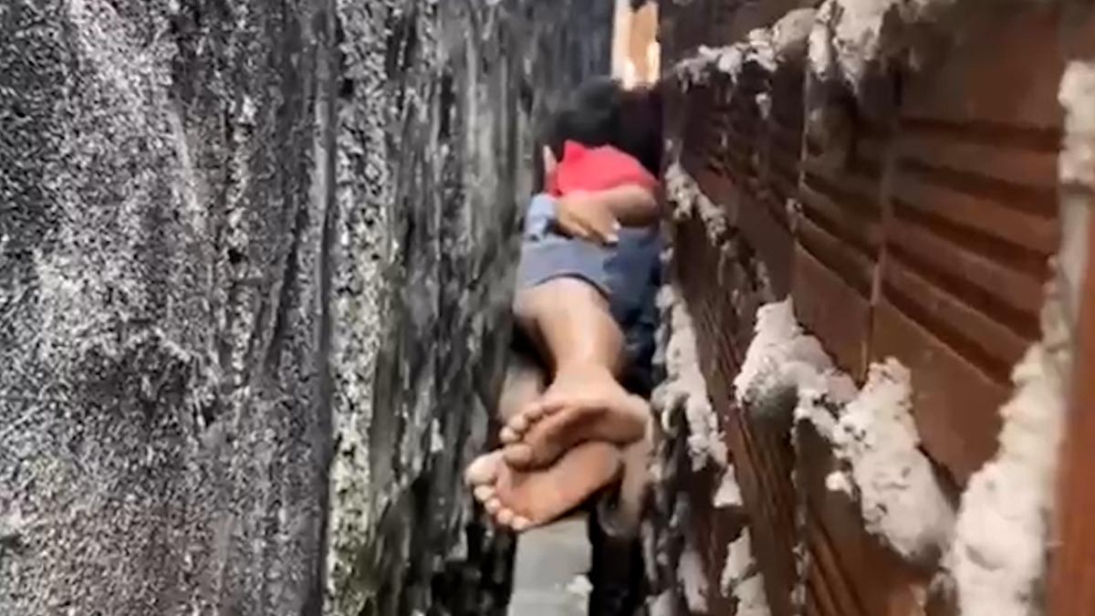 Rescuing a boy trapped between 2 walls while climbing onto the roof to catch a cat.