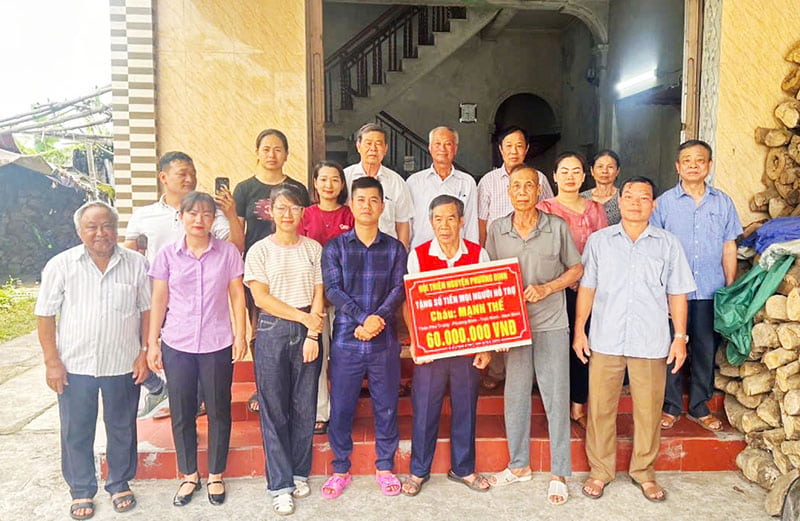 Anh Toàn (thứ 4 từ trái qua, hàng đầu tiên) cùng nhóm thiện nguyện, cán bộ thôn, xã trao tặng số tiền mọi người giúp đỡ cho hoàn cảnh khó khăn. Ảnh: Nhân vật cung cấp.