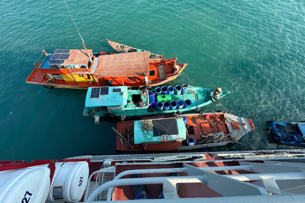 Ghe của ngư dân cập mạn Tàu 527 nhận nước ngọt. Ảnh: Định Thắng