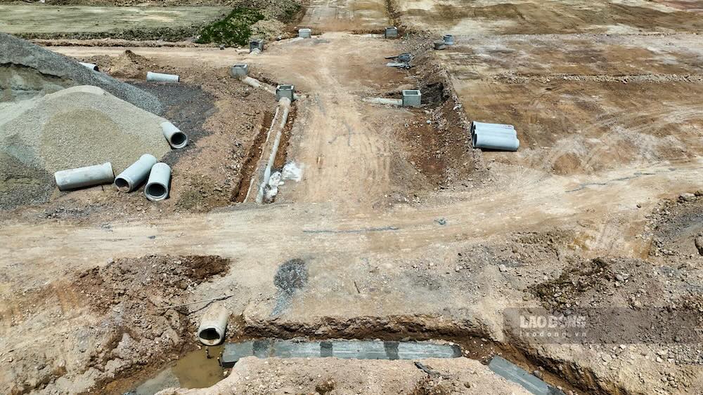 Tại khu tái định cư, phần lớn nền đất đã được san gạt, hệ thống thoát nước lắp đặt cơ bản; nhìn từ trên cao, các ô đất đã hình thành rõ ràng. 