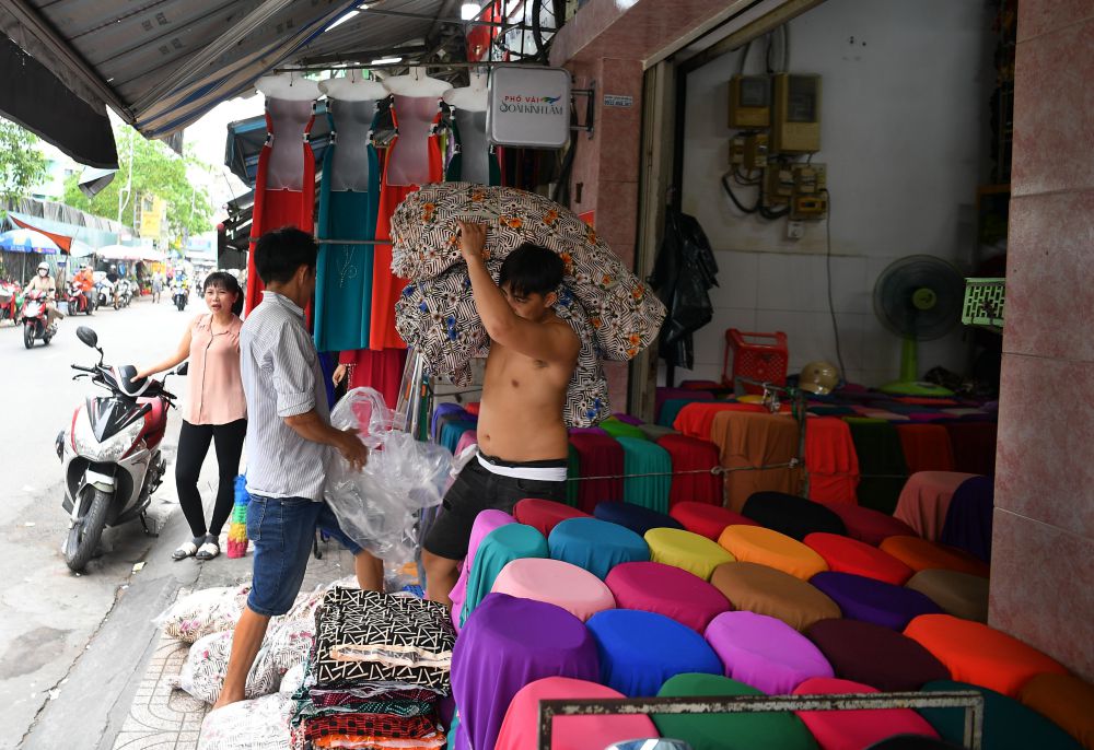 Hoạt động vận chuyển vải diễn ra trên vỉa hè, nơi người lao động bốc xếp hàng hóa liên tục để phục vụ nhu cầu mua bán sỉ lẻ trong ngày. Ảnh: Việt Văn