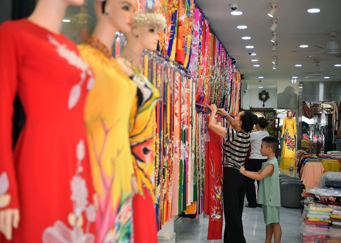 Gian hàng áo dài rực rỡ sắc màu thu hút khách lựa chọn, nơi các mẫu vải truyền thống được trưng bày hiện đại. Ảnh: Việt Văn