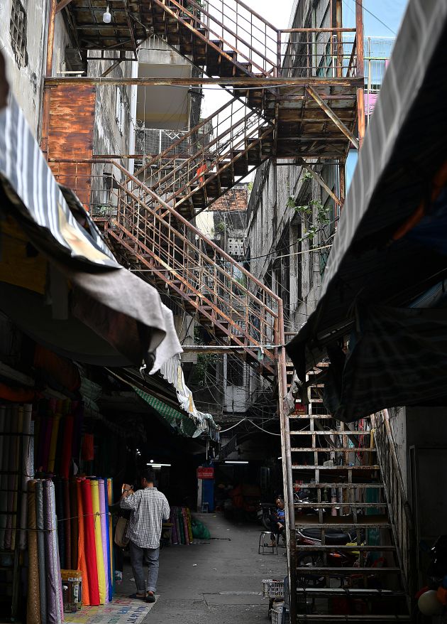 Một lối đi phía sau chợ với hệ thống cầu thang sắt cũ kỹ để thoát hiểm. Ảnh: Việt Văn