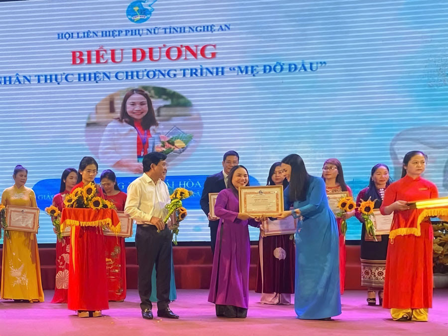 Cô Hòa (áo dài tím) tham gia thực hiện chương trình “Mẹ đỡ đầu” của Hội Liên hiệp Phụ nữ tỉnh Nghệ An. Ảnh: Nhân vật cung cấp