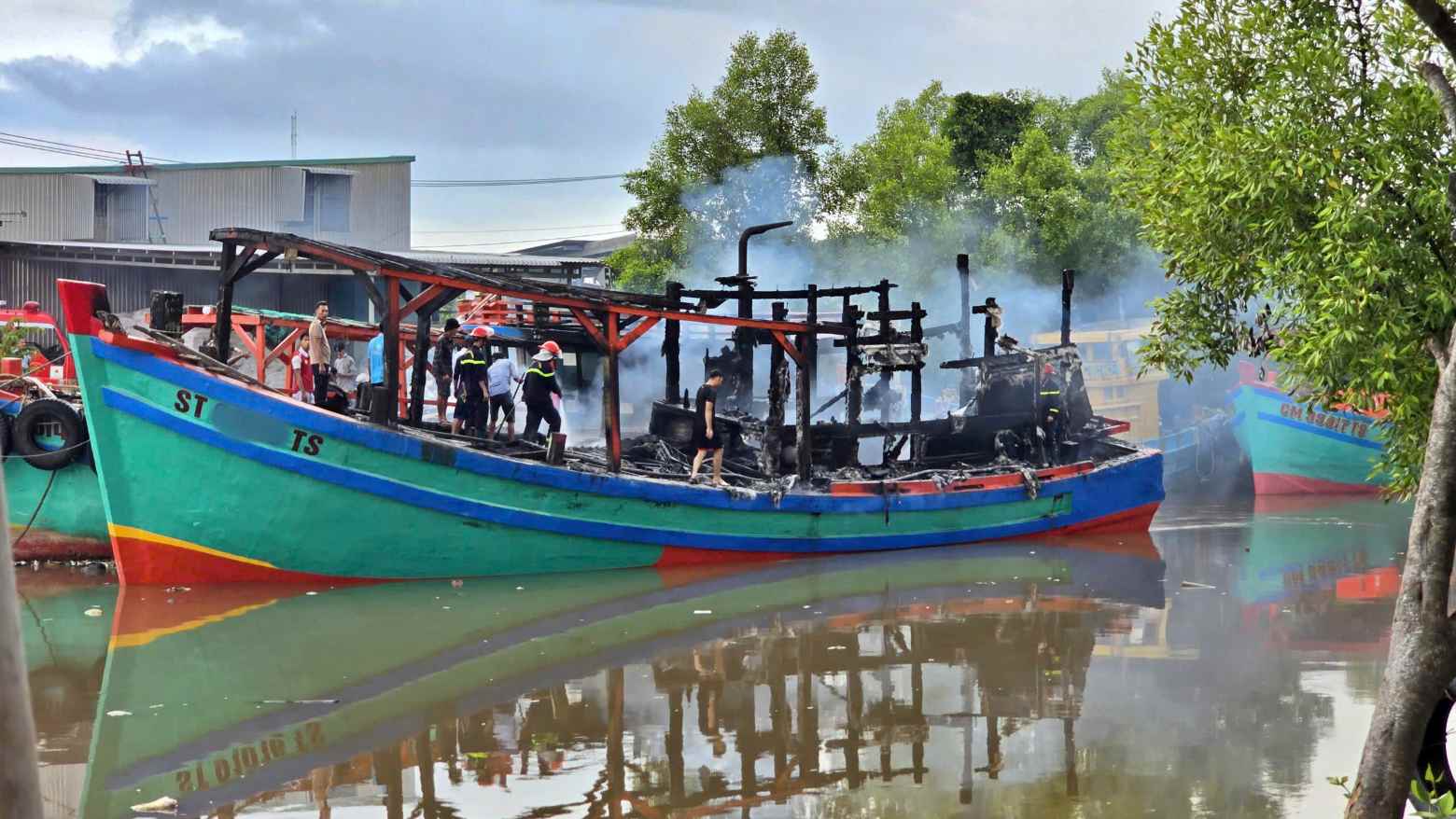 The fire was first discovered at a fishing boat docked at Nha Mat estuary, Ca Mau. Photo: Border Guard provided.