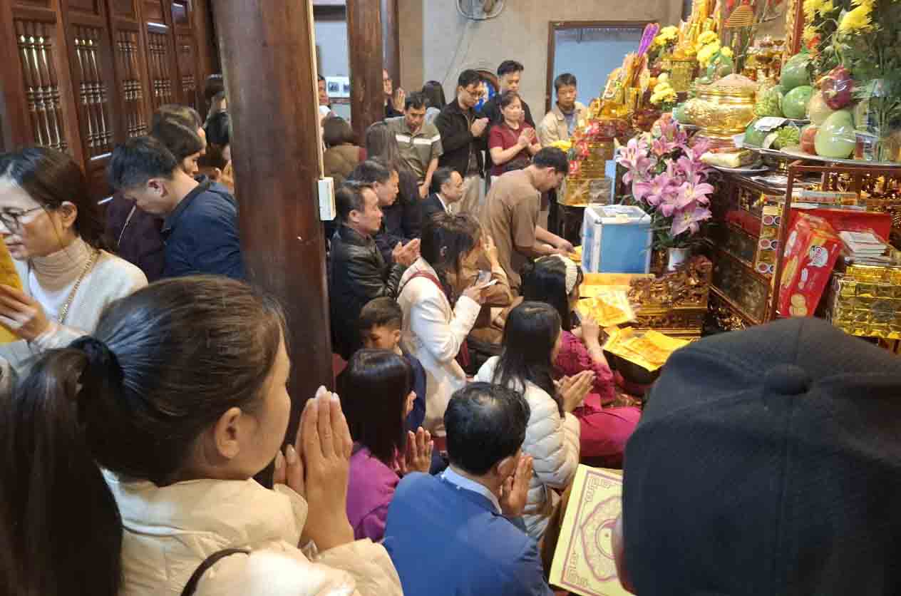 Les touristes prient pour la chance au vestige du temple Chợ Củi. Photo: Trần Tuấn
