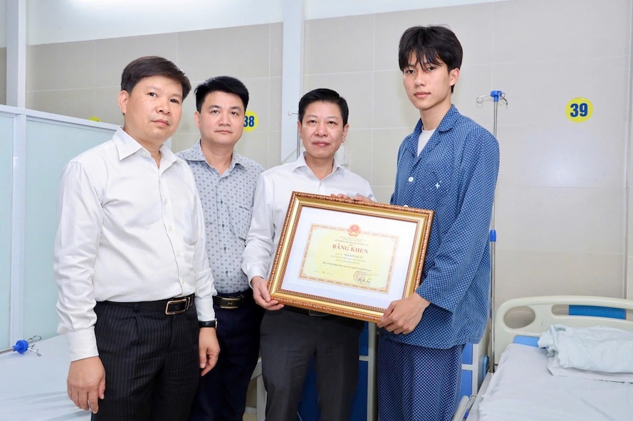 ホアン・ミン・ソン教育訓練大臣代行の委任を受け、グエン・スアン・アン・ベト学生・生徒局副局長が、グエン・レ・トゥー学生の勇敢な精神を見舞い、励まし、称賛しました。写真:教育訓練省