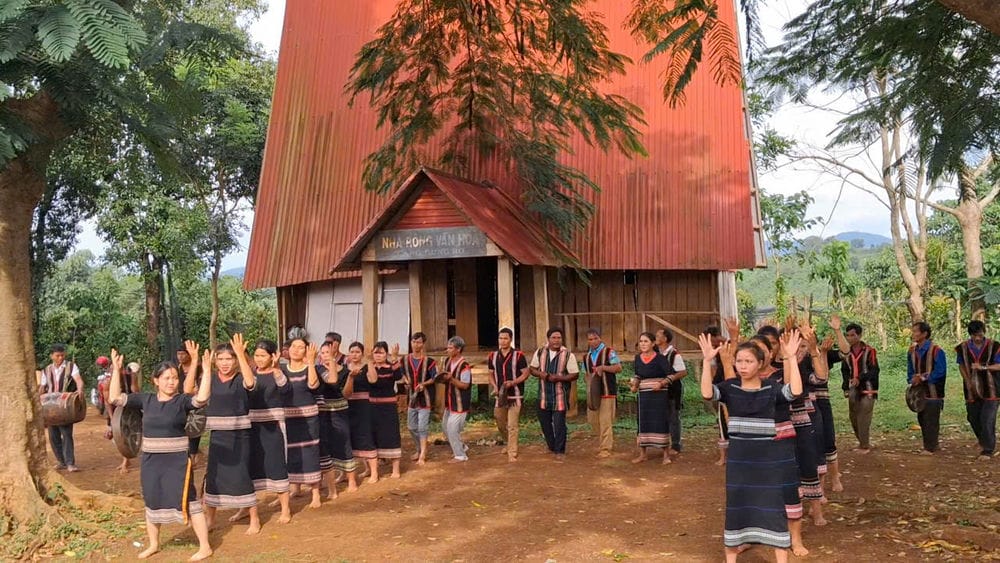 Women dancing xoang and men playing gongs by the roof of a communal house in Gia Lai. Photo: Thanh Tuan