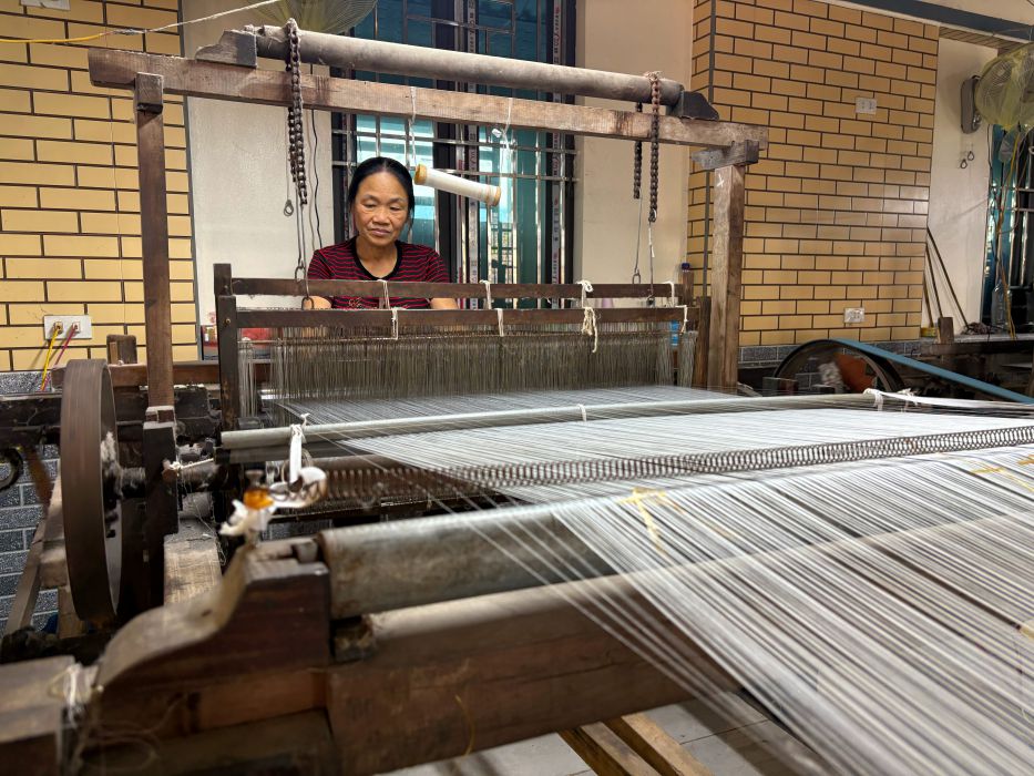 Tiếng thoi đưa lạch cạch đều đặn vang cùng nhịp chân dậm, tay giật của những người thợ cần mẫn bên khung cửi. Ảnh: Phạm Huyền