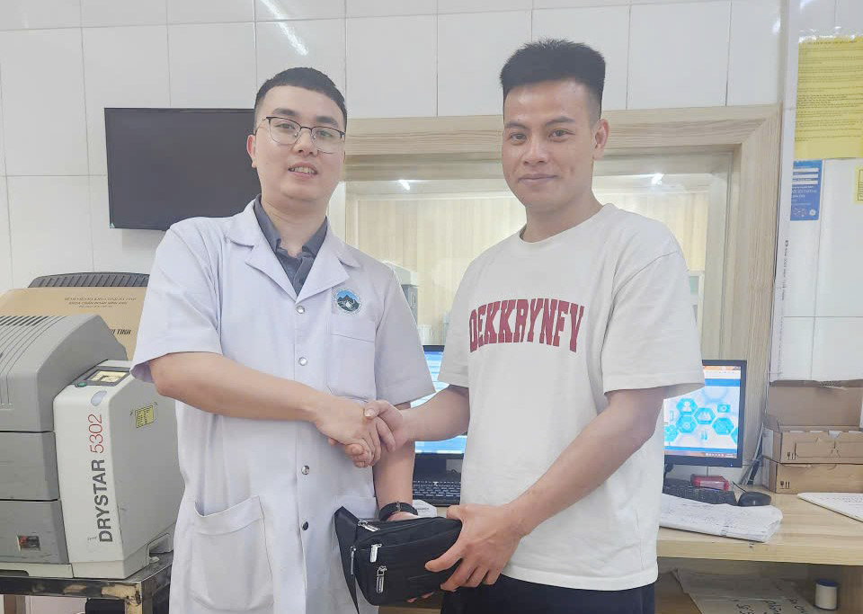 ホアンさん(左)が落とし主に財産を返却。写真:ハン・ローン