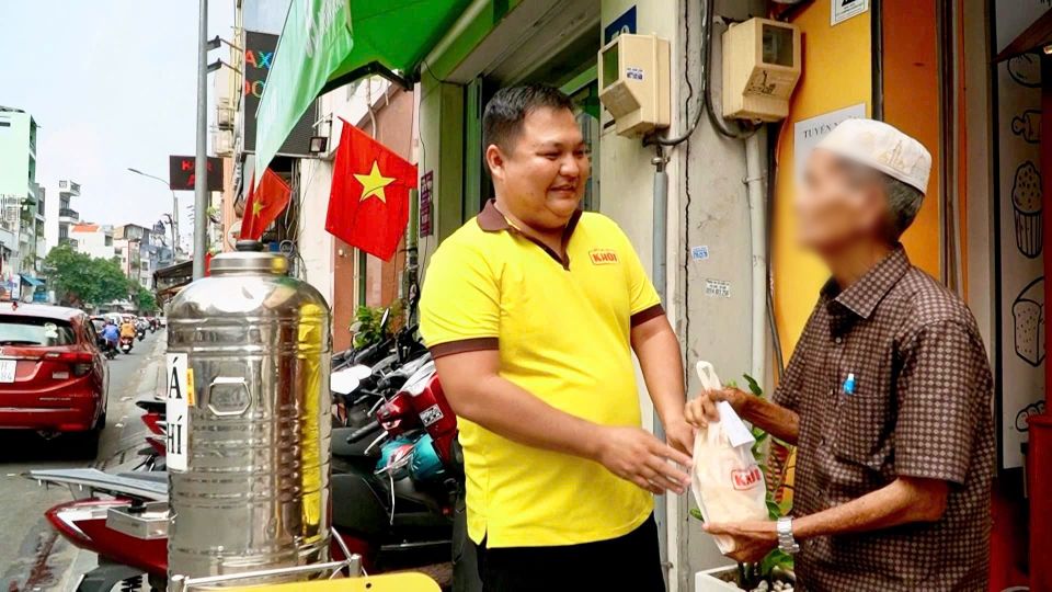  Ông Huỳnh Nam Vân (bên phải ảnh) là khách hàng thân thiết tại cửa hàng bánh mì “treo”. Ảnh: Mai Anh