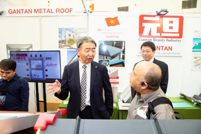 M. Seigo Kato, PDG de Gantan, présente le matériau de toit métallique résistant aux catastrophes naturelles aux visiteurs du stand de Gantan. Photo: NH.
