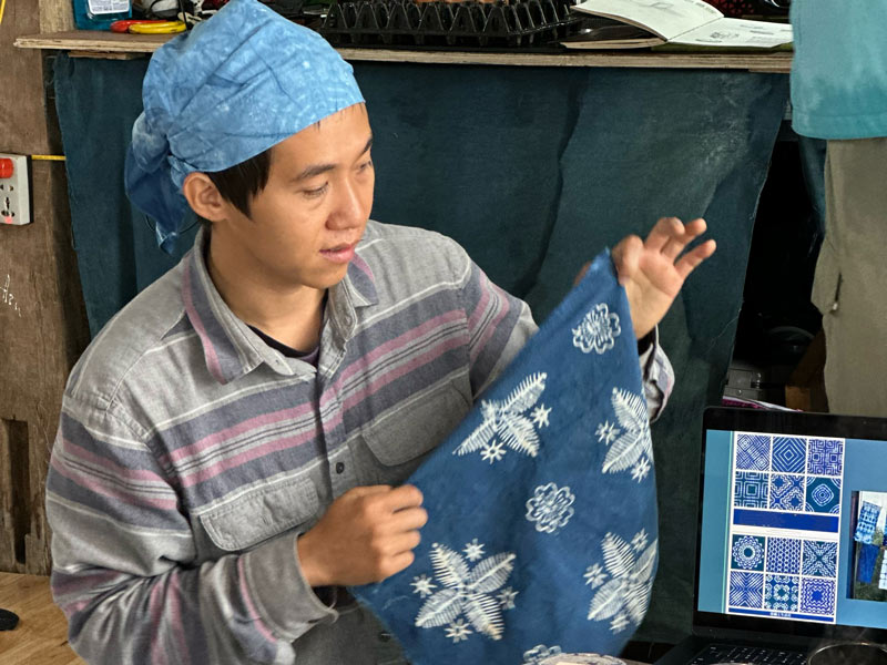 Anh Thịnh hướng dẫn chi tiết về màu chàm và những dụng cụ vẽ hoa văn trong quá trình nhuộm chàm. Ảnh: Ánh Dương 