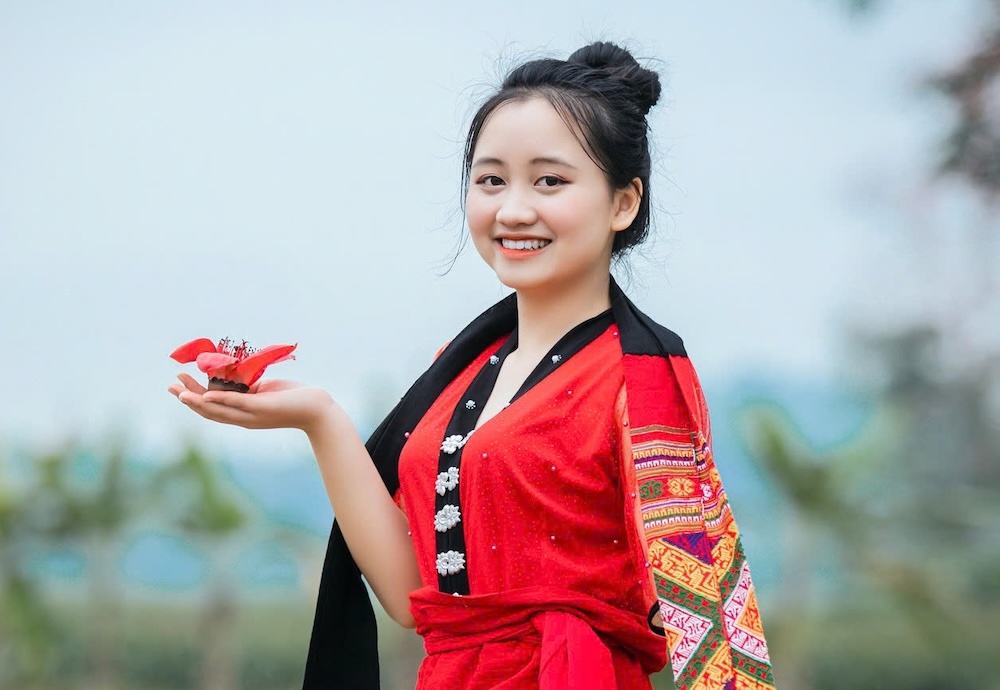 گردشگران از گرفتن عکس در زیر شکوفه‌های قرمز پر جنب و جوش لذت می‌برند و لحظات زیبایی را در میان حومه آرام ثبت می‌کنند. عکس: رانگ دونگ