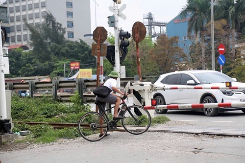 Bất chấp nguy hiểm, nhiều người vẫn vượt rào chắn đường sắt. Ảnh: Hoàng Hà