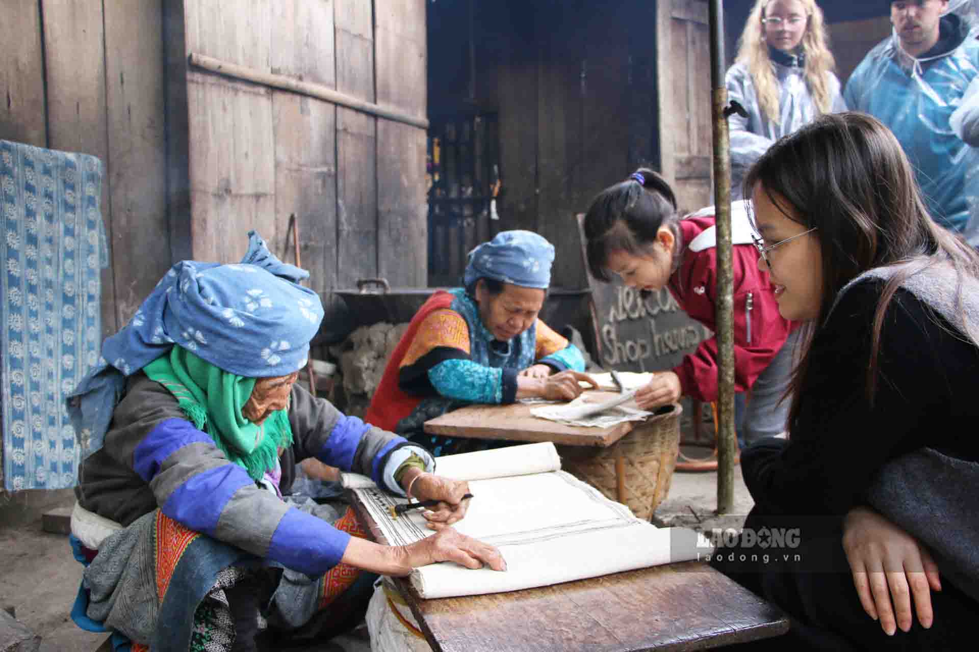 예술가 숭 티 꺼의 린넨 천에 그린 밀랍 그림이 관광객들의 특별한 관심을 받고 있습니다. 사진: 응우옌 뚱