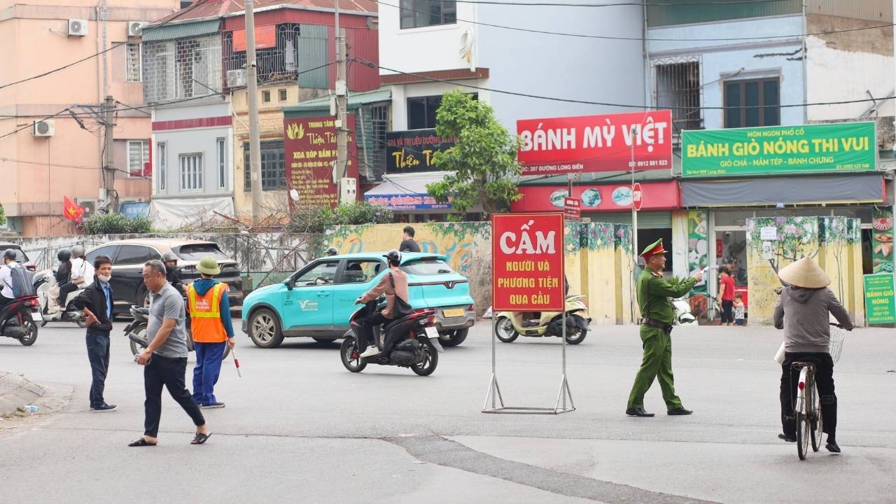 Lực lượng chức năng túc trực, điều tiết giao thông sau khi cấm phương tiện qua cầu Long Biên. Ảnh: Kim Thủy