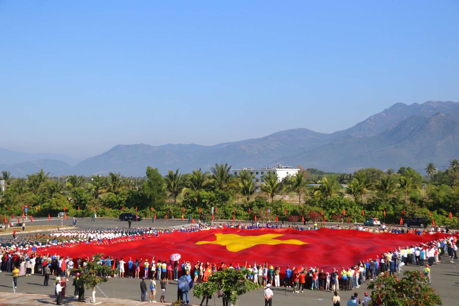 Lá cờ Tổ quốc rộng 2.166 m2 được tất cả các đại biểu tham gia cùng nắm tay trải dài trên quảng trường. Ảnh: Phương Linh