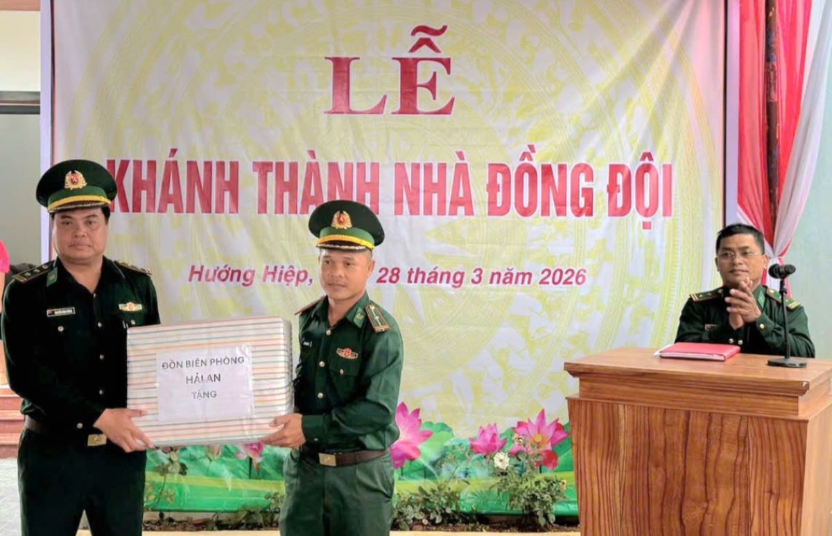 Trung tá Nguyễn Đình Cường (trái ảnh) - Đồn trưởng Đồn Biên phòng Hải An tặng quà cho Thiếu tá Hồ Văn Quỳnh tại lễ bàn giao nhà. Ảnh: H.Nguyên
