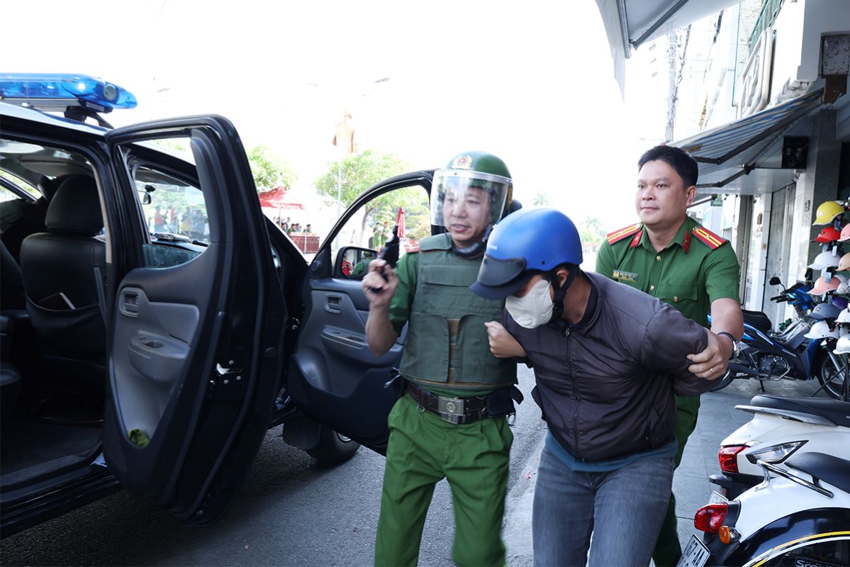 Khống chế đối tượng cướp tài sản về trụ sở công an. Ảnh: Vũ Tiến