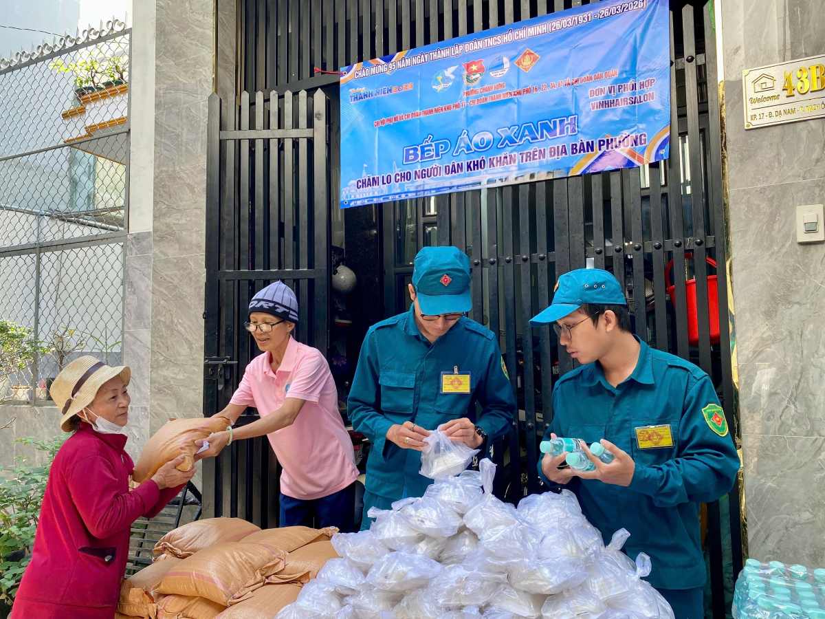 Những thành viên của bếp áo xanh phát đồ ăn và quà cho người lao động khó khăn trên địa bàn phường Chánh Hưng (TPHCM). Ảnh: Minh Tâm
