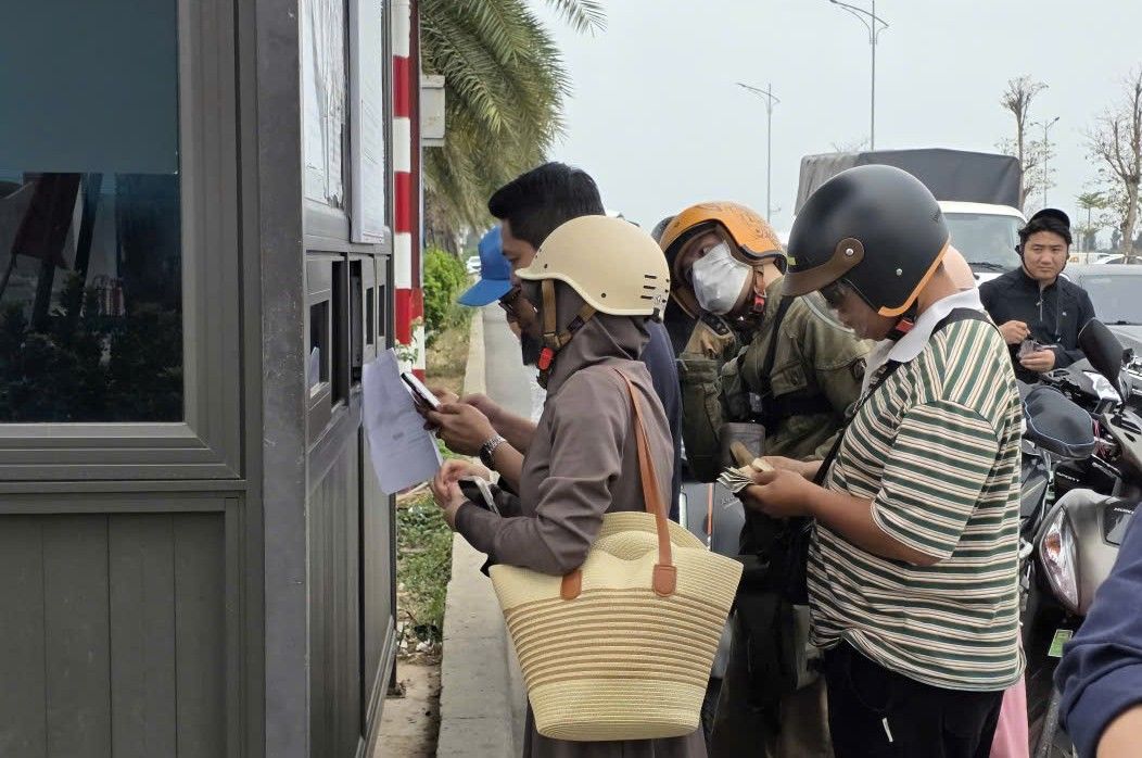 Du khách xếp hàng mua vé qua phà. 