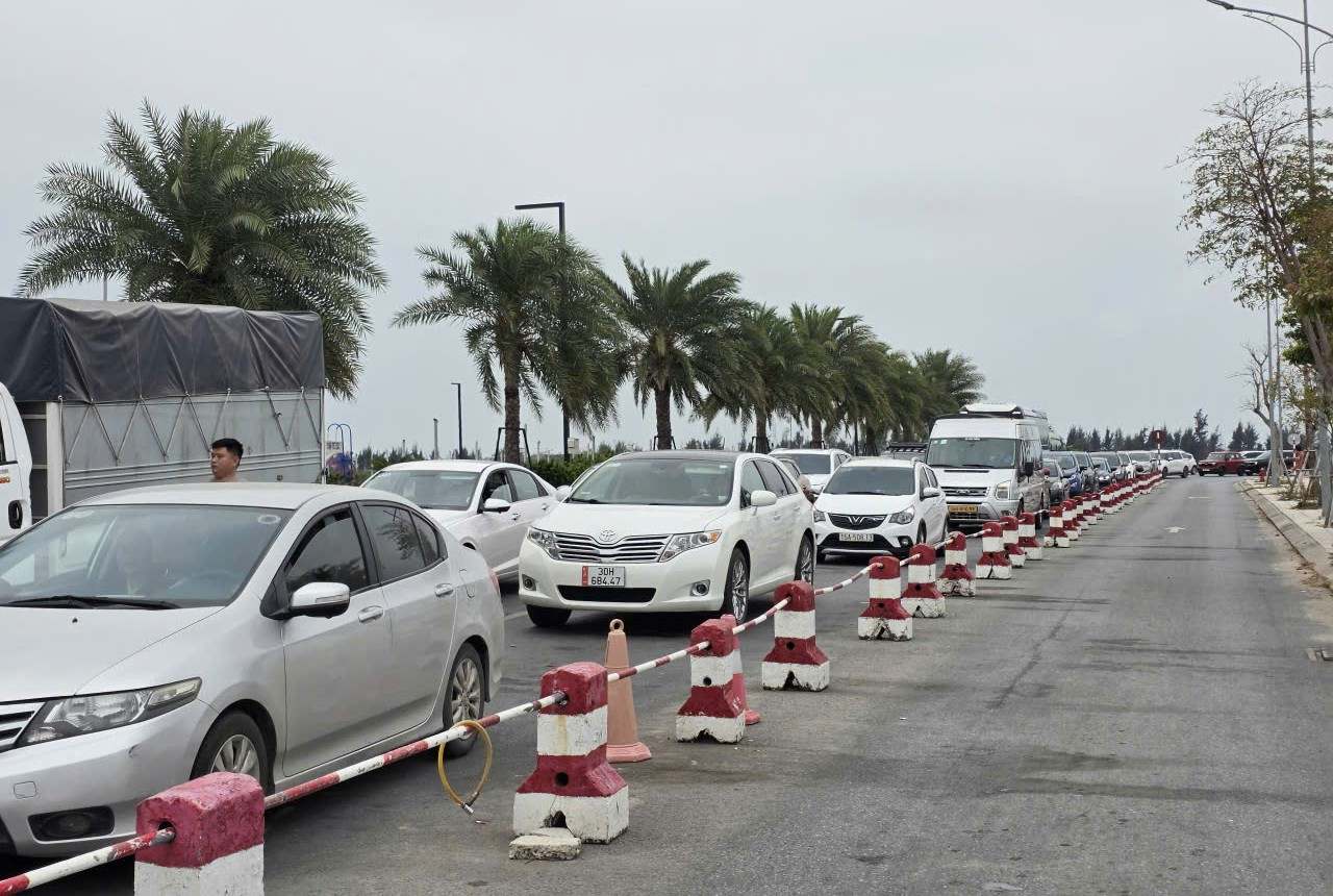 Hàng xe nối dài trong sáng 28.3 tại bến phà Đồng Bài để di chuyển sang đảo Cát Bà. 