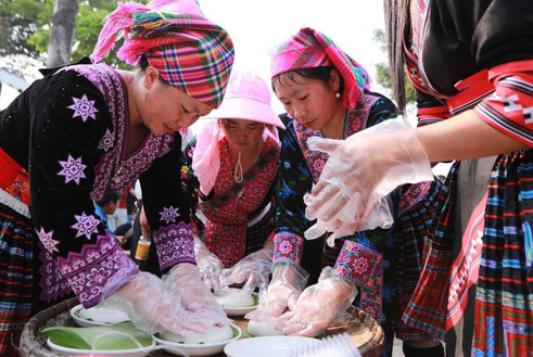 Các thành viên nữ trong đội đảm nhận phần việc nhẹ hơn như cắt lá để đựng bánh giầy sau khi giã xong.