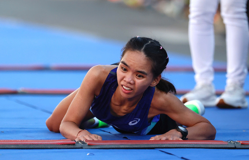 Cô cố gắng vươn tay chạm vạch và trườn qua đích, bấm đừng đồng hồ để hoàn thành phần thi.