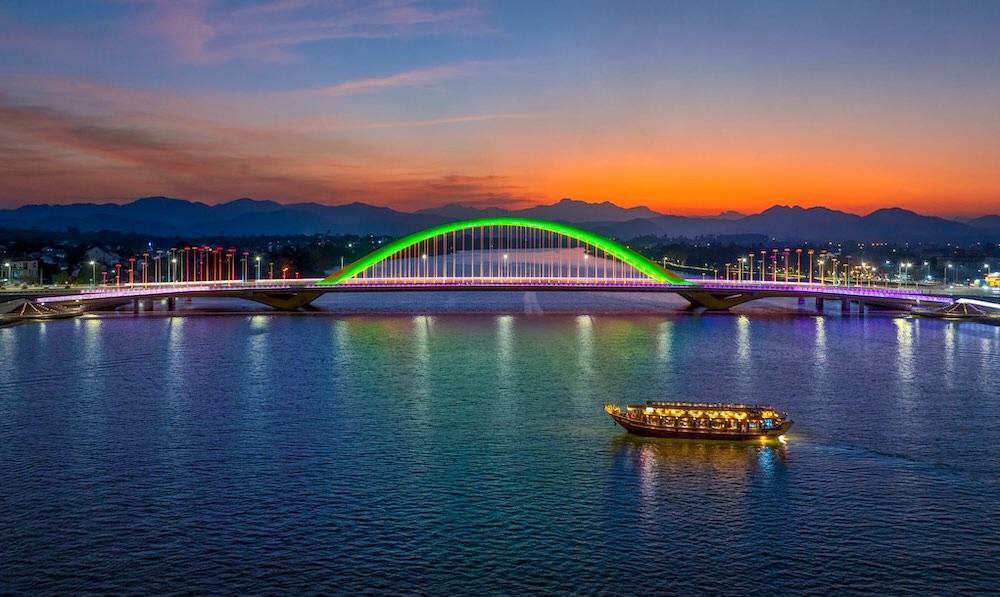 Ánh hoàng hôn cuối ngày dần tắt, những chiếc thuyền trên dòng Hương Giang lên đèn, những cây cầu cũng hiện lên rực rỡ.